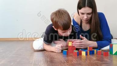 妈妈和儿子一起玩木制彩色教育玩具<strong>积木</strong>躺在地板上。 他们建了一个红色的<strong>盒子</strong>。